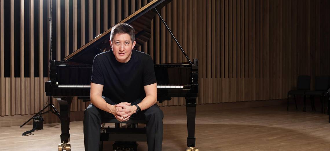 Freddy Kaempf vor dem Klavier sitzend