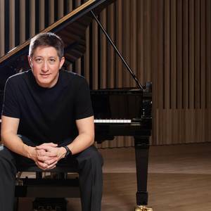 Freddy Kaempf vor dem Klavier sitzend