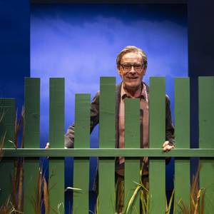Christoph Reiche hinter einen grünen Gartenzaun stehend