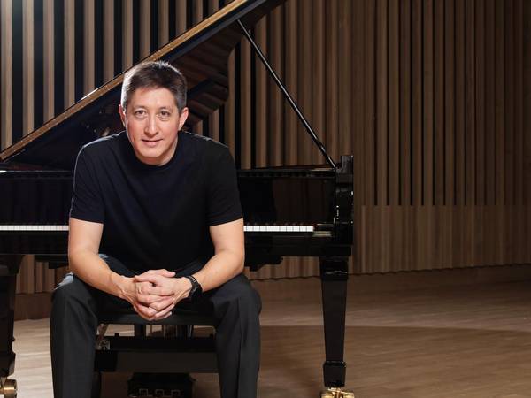 Freddy Kaempf vor dem Klavier sitzend