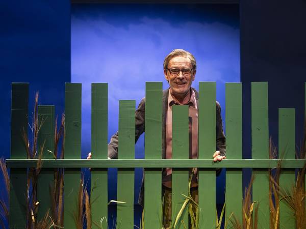 Christoph Reiche hinter einen grünen Gartenzaun stehend