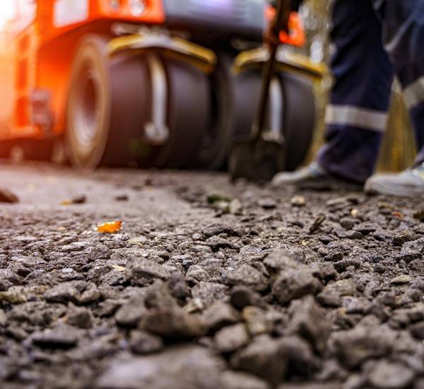 Eine Asphaltwalze setzt eine neue Straße