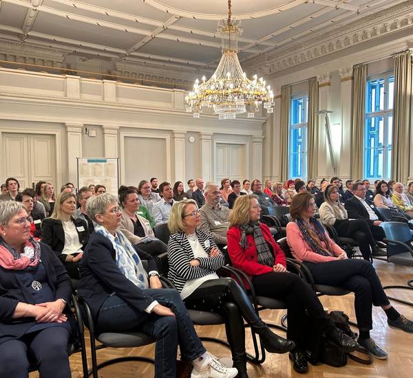 Mitarbeitende der Kreisverwaltung, der Agentur für Arbeit und des Jobcenters nehmen an der Konferenz im Kreistagssaal in Güstrow teil.